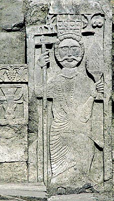 Das flache Relief zeigt eine Figur mit Krone und Brokatgewand.