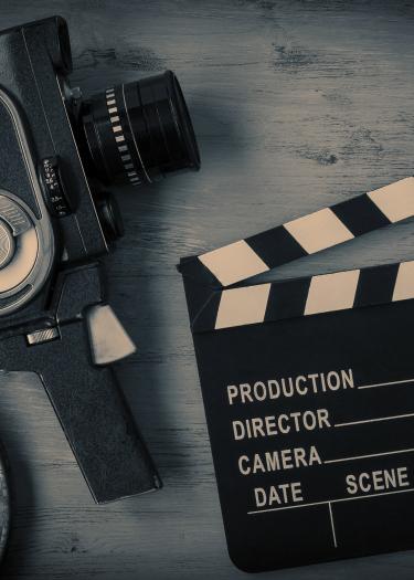 Symbolbild mit Filmspule, Handkamera und Regieklappe